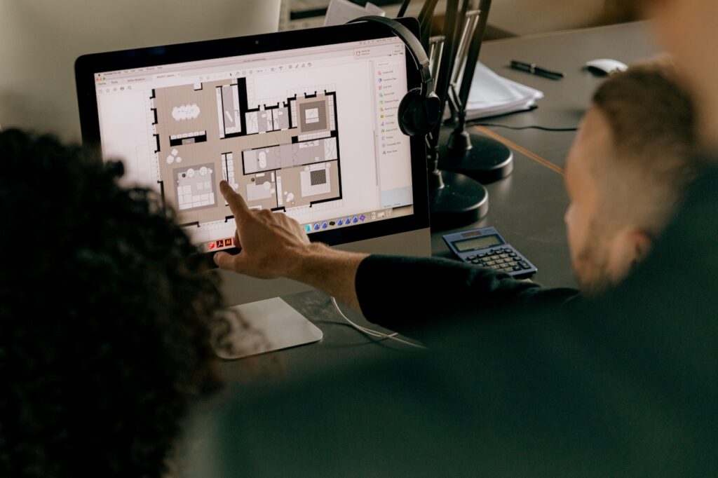 Discussing floor plans, viewed on computer at desk.